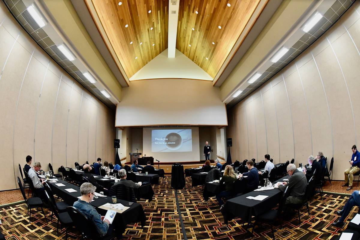 A scientific session under way in a timber-vaulted conference room