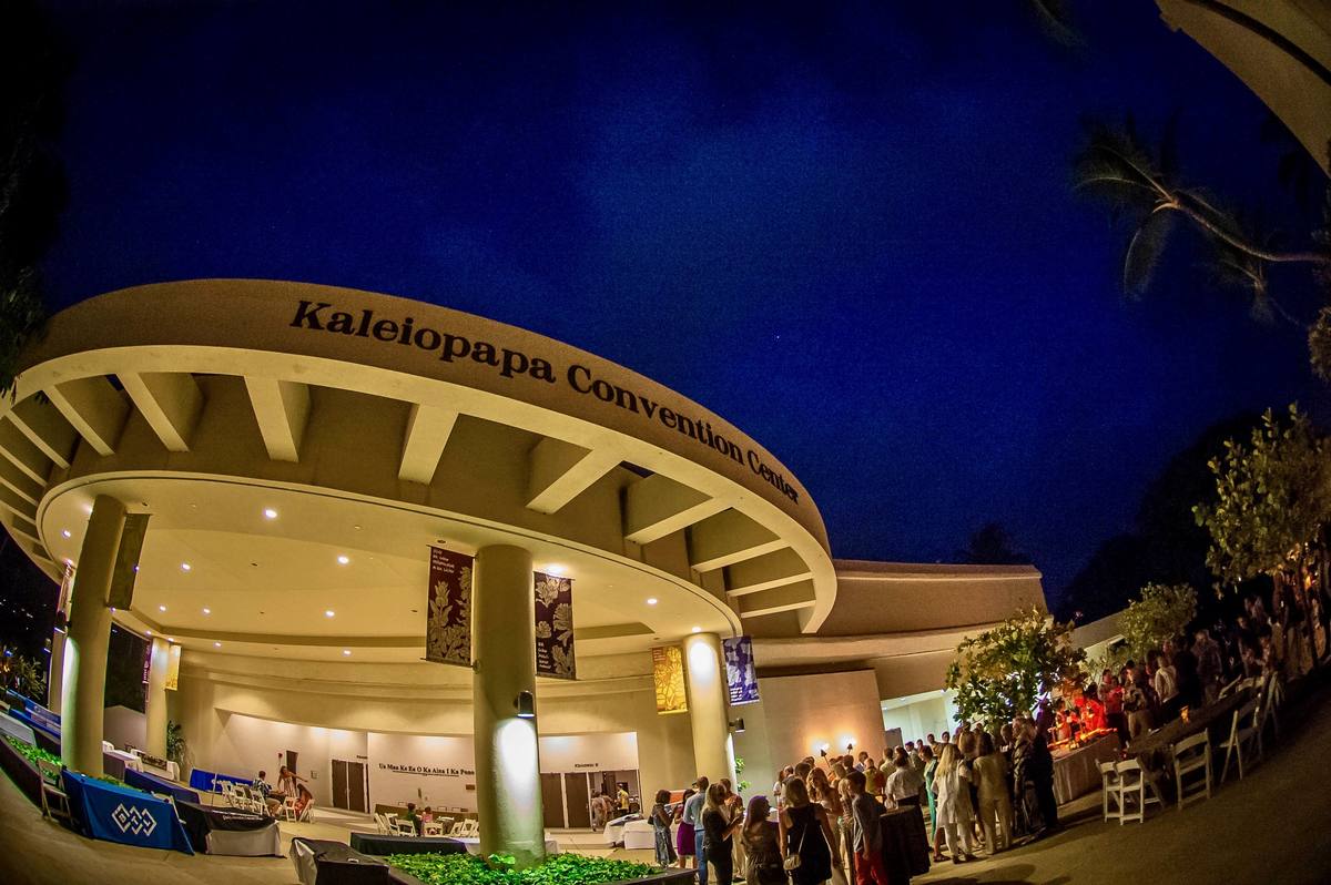 Guests gather outside the Kaleiopapa Convention Center at dusk under a deep blue sky
